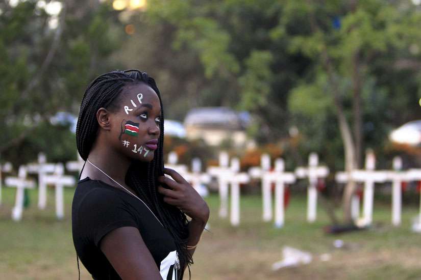 A student wearing face paint walks past wooden crosses during an April 14 memorial concert in Nairobi, Kenya, for the 147 people killed in an attack on Garissa University College. Pope Francis is calling for perpetrators of extremist violence in Kenya &quot;t o come to their senses and seek mercy.&quot; 