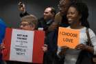 People hold signs during a Jan. 31 protest at Washington Dulles International Airport in Virginia.