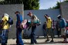  Central American immigrants who had just arrived Nov. 13 to Tijuana, Mexico, wait in line for a meal at a migrant shelter.