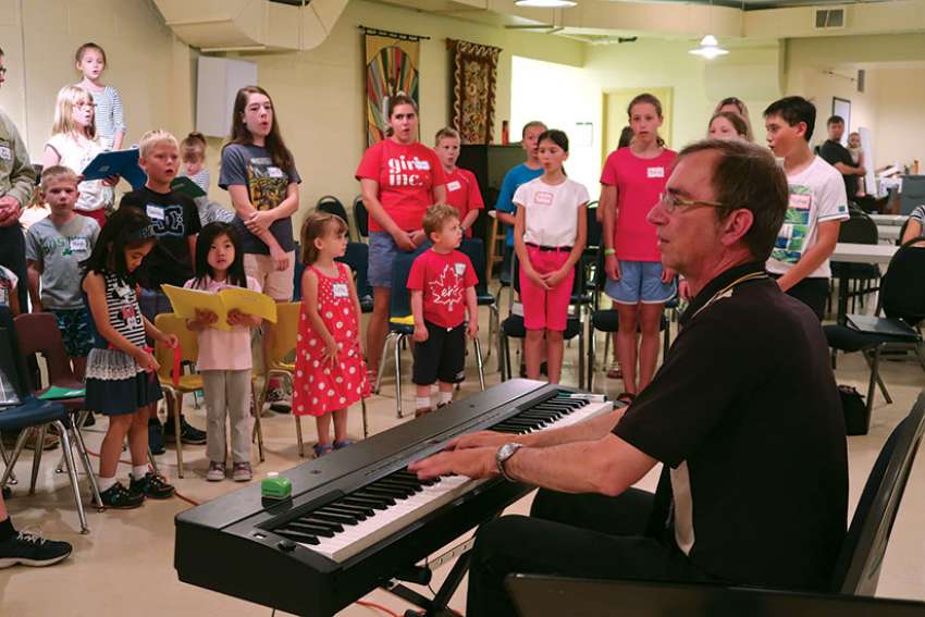 Uwe Lieflander leads a warm up exercise with Sparrows from Immaculate Conception Parish in Port Perry, Ont.