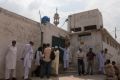 Members of the media and residents gather outside a mosque in this photo dated Aug. 23, 2013 near the locked family house of Rimsha Masih, a Pakistani Christian girl who was accused of blasphemy, on the outskirts of Islamabad.