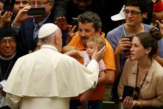 Pope Francis greets a baby during his general audience in Paul VI hall at the Vatican Aug. 1.