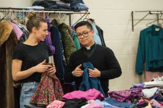 Benedicte LeMaître and Fr. Geoffrey Angeles sort through new clothes donated to St. Elizabeth’s Closet at St. Mary’s Cathedral. 