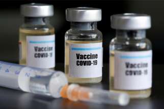 A file photo shows small bottles labeled with a &quot;Vaccine COVID-19&quot; stickers and a medical syringe. Spanish Cardinal Antonio Canizares Llovera of Valencia made headlines June 5, 2020, when he described as a &quot;work of the devil&quot; attempts to find a COVID-19 vaccine using cell lines created from fetuses aborted voluntarily decades ago.
