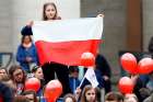 A girl holds a Polish flag as Pope Francis leads the Angelus March 19 in St. Peter&#039;s Square at the Vatican. 