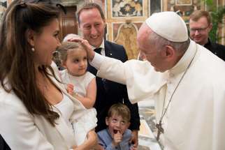 Pope Francis greets family members during an audience with participants in an international congress on protecting children in a digital world, at the Vatican Oct. 6. 