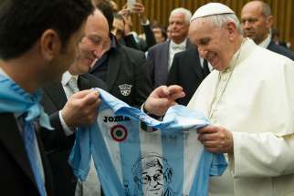 Pope Francis holds a jersey offered to him as a gift after leading a special audience for the Lazio sport association in Paul VI hall at the Vatican May 7. 