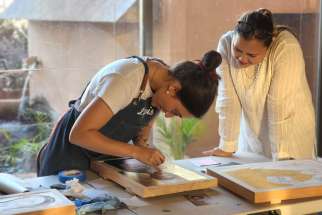 A participant of a former Kalos Iconography retreat work on gilding the gold of an in-progress icon. 