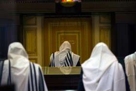 Jewish worshippers covered in prayer shawls pray Nov. 19 at a synagogue in Jerusalem where two Palestinian militants killed four rabbis and a policeman. Pope Francis condemned the &quot;unacceptable episodes of violence&quot; in Jerusalem, episodes that &quot;do not sp are even places of worship.&quot;