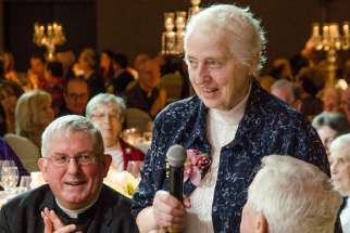 Toronto Cardinal Thomas Collins watches as Sister Andrea Dumont accepts Catholic Missions’ missionary award April 24 on behalf of all “unsung heroes” referring to all missionaries working in Canada.