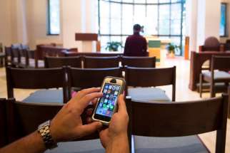 This photo illustration shows someone using a cellphone inside a Catholic chapel in Washington Oct. 27.