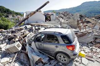 A car covered by debris is seen near a collapsed house in Pescara del Tronto, Italy, Aug. 26. Pope Francis announces his intention to visit towns struck by an Aug. 24 earthquake, which left hundreds dead.