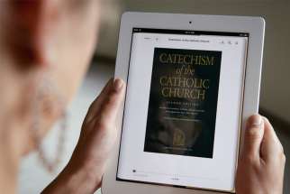 A woman displays the e-book version of the Catechism of the Catholic Church on an iPad.