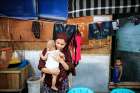 A Rohingya woman holds her 2-month-old baby in early February at a refugee shelter in Medan, Indonesia. The woman and her husband fled persecution in their village in Myanmar and have been waiting for two years to be resettled to Malaysia or Australia.