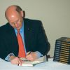 Author and Catholic Register columnist Michael Coren signs a copy of his new book Heresy: The Ten Lies They Spread About Christianity at a book launch April 24.