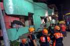 Rescuers view a damaged building following an earthquake July 6 in the Philippine province of Leyte. A week after the magnitude 6.5 earthquake hit the province, hundreds of residents continue to live in temporary shelters.