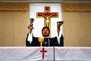  A priest celebrates Mass in 2012 in a makeshift chapel in a village near Beijing. For the first time in decades, all of the Catholic bishops in China are in full communion with the pope, the Vatican announced Sept. 22.