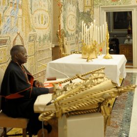 Congolese Cardinal Laurent Monsengwo of Kinshasa offers spiritual reflections to Pope Benedict XVI (seen through the doorway) and Vatican officials Feb. 26 in the Redemptoris Mater Chapel in the Apostolic Palace. The pope and top Vatican officials were on a weeklong Lenten retreat Feb. 26-March 3.