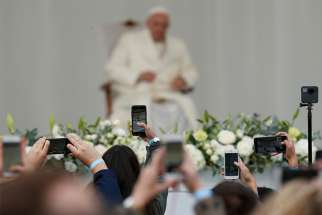 People use phones to capture images of Pope Francis as he leads a meeting with young people in the square adjacent to the cathedral in Vilnius, Lithuania, Sept. 22. 