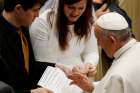 Pope Francis blesses the marriage certificate of a couple during his general audience in Paul VI hall at the Vatican Dec. 14, 2016.