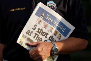 Steve Schuh, county executive of Anne Arundel County, Md., holds a copy of the Capital Gazette June 29, the day after a gunman killed five people and injured several others at the Annapolis, Md., newspaper.