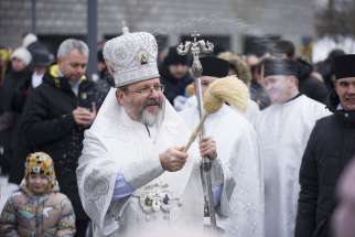 Major Archbishop Sviatoslav Shevchuk, head of the Ukrainian Greek Catholic Church, sprinkles worshippers with water during the blessing of water on the Dnipro River after he celebrated a Divine Liturgy Jan. 6, 2024, at the Patriarchal Cathedral of the Resurrection of Christ in Kyiv.