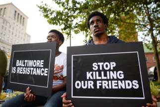 People gather to remember all victims of police violence during a rally outside City Hall in Baltimore July 27. Baltimore&#039;s archbishop William E. Lori called a recently released report by the U.S. Department of Justice on the systemic abuses by the city&#039;s police &quot;sobering and distressing.&quot;
