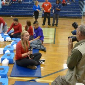 Cardinal Leger Secondary School student Paris Dickinson is interviewed by a TV station as the students in background continue with the CPR world record attempt.