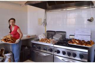 Graziana Pistorio, a volunteer, prepares food donated by local bakeries at the Caritas centre in Catania, Sicily.