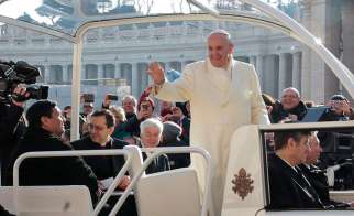 Fabian Baez, a priest from a church in downtown Buenos Aires, sits in the popemobile as Pope Francis arrives to lead his general audience in St. Peter&#039;s Square at the Vatican Jan. 8. The pope spotted the priest in the crowd and invited him to board the p opemobile.