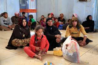 Displaced families await temporary shelter in Kirkuk, Iraq, June 11. Catholic and Orthodox patriarchs called for the rapid liberation of areas under control of the Islamic State group to end ethnic and religious genocide.