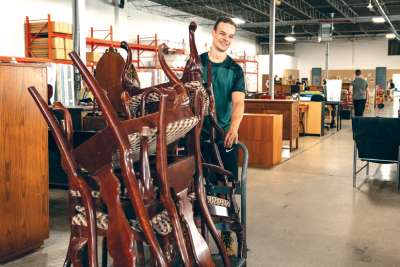 A worker has some chairs on the move at the Furniture Bank, where they deal with helping needy families all year round. 