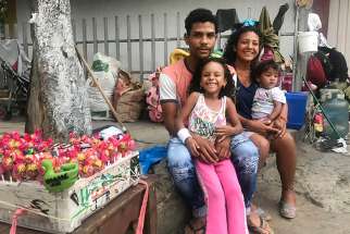 Venezuelan Roberto Sanchez, his wife and two young daughters pose for a photo in Cucuta, Colombia Feb. 9, 2019. The family lived at a Catholic-run shelter for the first two weeks, then moved out, only to be evicted by their landlord. Now they are living in the street and sell sweets to make a living, while they save up to rent a new place. 
