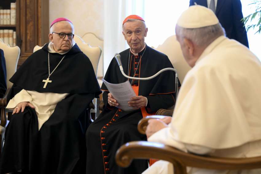 U.S. Archbishop J. Augustine Di Noia, adjunct secretary of the Dicastery for the Doctrine of the Faith, looks on as Cardinal Luis Ladaria, prefect of the dicastery, speaks to Pope Francis about the work of the Pontifical Biblical Commission during an audience April 20, 2023, in the library of the Apostolic Palace at the Vatican.