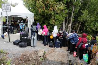 A group of Haitians wait to cross the U.S.-Canada border into Quebec from New York in late August 2017.