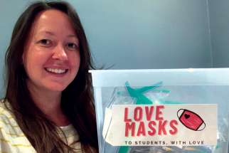 Toronto teacher Rachel Thomas holds a bin full of Love Masks, masks that will be provided to students who need them when they return to school this month.