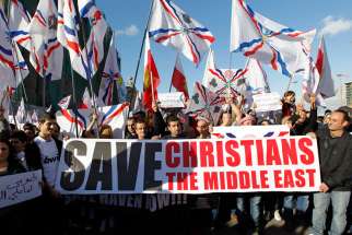 Assyrian Christians, who had fled Syria and Iraq, carry placards and wave Assyrian flags during a gathering in 2015 in front of U.N. headquarters in Beirut.
