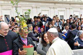 Sergio Guidi, president of the Italian tree conservation association, &quot;Patriarchi della Natura,&quot; presents a potted tree to Pope Francis at his general audience April 18. The association presented eight saplings from tree species that are threatened or endangered with extinction. The saplings were planted in the Vatican Gardens.