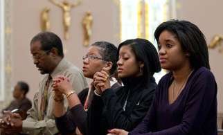 A family prays before Sunday Mass starts at St. Joseph&#039;s Catholic Church in Alexandria, Va., Nov. 27, 2011.