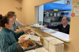 Volunteers from the 2023-2024 St. Catharines Out of the Cold program work together to prepare takeaway meals for those in need.