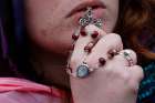 A woman holds a rosary with an image of Pope Francis as the Pope delivers his Easter message and blessing &quot;urbi et orbi&quot; from the central balcony of St. Peter&#039;s Basilica at the Vatican 2015.