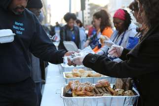 Volunteers with Catholic Charities&#039; St. Maria&#039;s meals program in Washington serve dinner March 8 to the homeless.