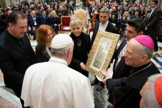 Pope Francis accepts a gift during an audience with a group of international performers at the Vatican Dec. 13, 2019. The performers, including U.S. singer Lionel Richie, were scheduled to perform at the Vatican&#039;s Christmas concert the next day.
