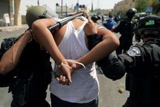 Israeli security forces arrest a Palestinian man following clashes outside Jerusalem&#039;s Old City July 21. 