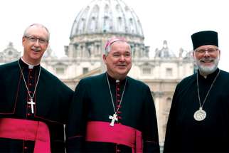 Canadian Archbishops Richard Smith of Edmonton, left, and Richard Gagnon of Winnipeg are pictured with Bishop Kenneth Nowakowski in front of St. Peter’s Basilica in Rome in 2017.