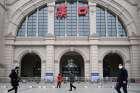 People walk past the closed Hankou Railway Station after the city was locked down following the outbreak of a new coronavirus in Wuhan, China, Jan. 23, 2020. Some churches in China have suspended community activities, including Mass, over fears of the deadly virus.