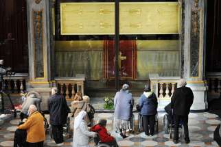 Faithful pray in front of the exposition of the Shroud of Turin in the Cathedral of Turin, Italy, March 30 2013. Pope Francis will visit Turin to venerate the shroud June 21-22. 