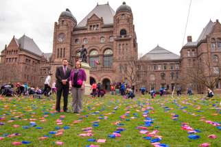 We Need A Law campaign director Mike Schouten and media relations assistant Niki Pennings on the lawn of Queen’s Park, where the campaign arranged a display of 100,000 pink and blue flags to represent abortions performed in Canada each year. 
