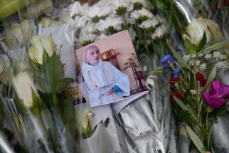 A photo of slain Father Jacques Hamel is seen among flowers at a makeshift memorial in Saint-Etienne-du-Rouvray, near Rouen, France, July 27.