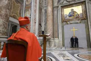 Cardinal Mauro Gambetti, archpriest of St. Peter&#039;s Basilica at the Vatican, watches as workers remove a box that had been cemented into the Holy Door at the basilica at the end of the Jubilee of Mercy in 2016 during a ceremony Dec. 2, 2024. The box was removed in preparation for Pope Francis opening the Holy Door Dec. 24.